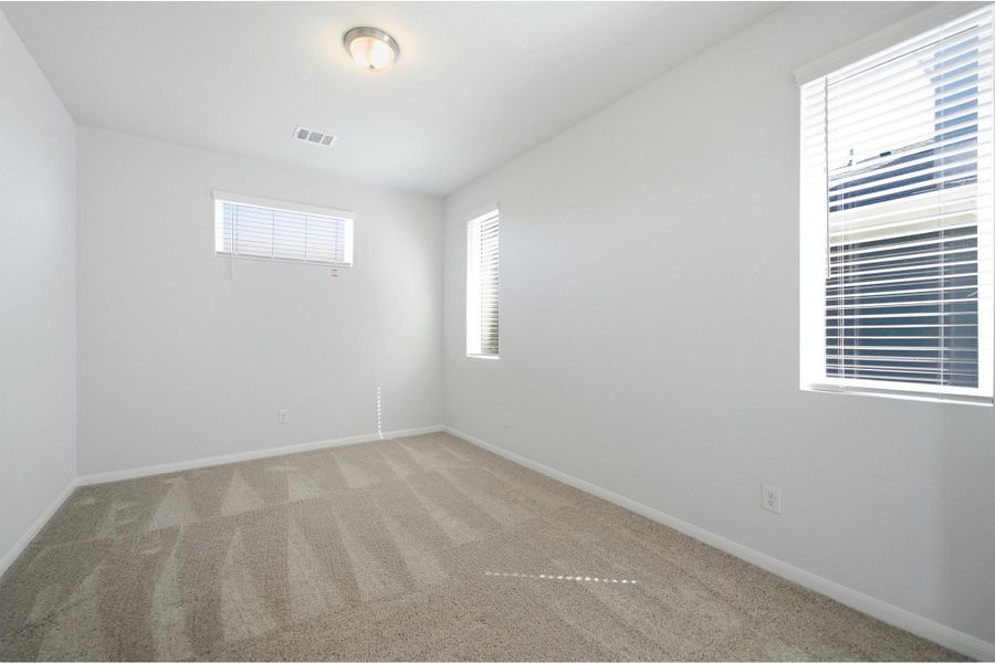 Spare room featuring light carpet and baseboards