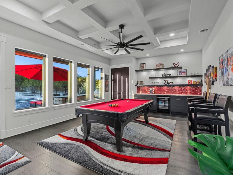 Playroom featuring a dry bar, billiards table, coffered ceiling, ceiling fan, and dark wood finished floors