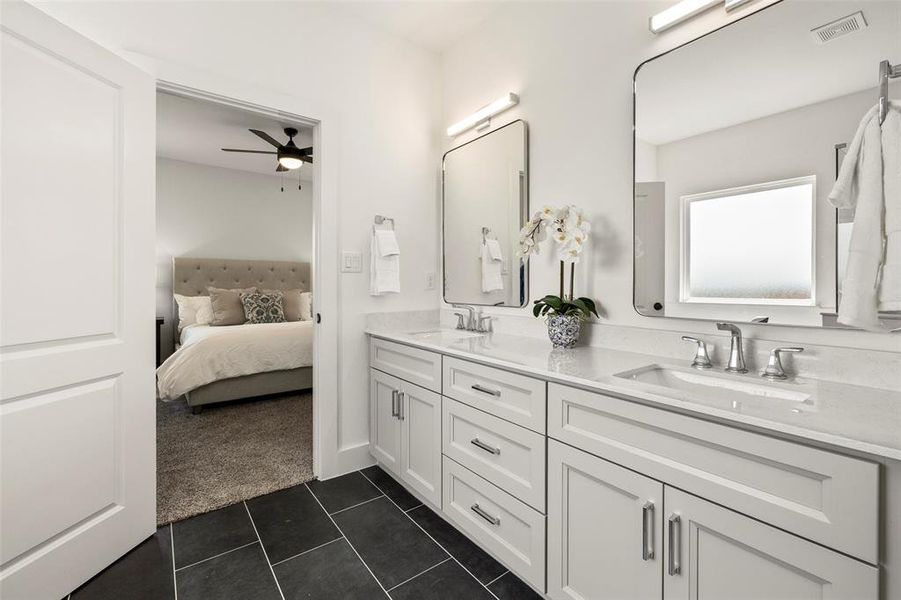 Bathroom featuring tile floors, large vanity, double sink, and ceiling fan