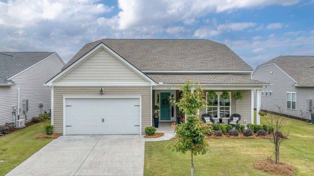 Front exterior of a new home in K. Hovnanian's® Four Seasons at Lakes of Cane Bay, Summerville, SC, highlighting curb appeal (Image 23).
