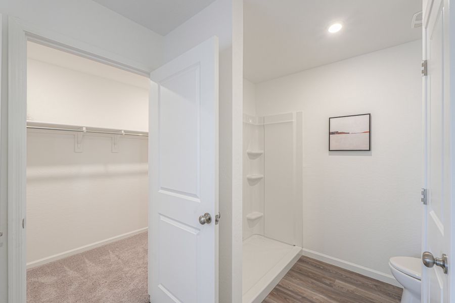 A bathroom with a shower unit and toilet. A bathroom with a shower unit and toilet.