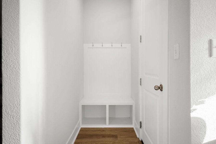 A built-in bench with integrated storage and coat hooks provides a functional and organized entry.