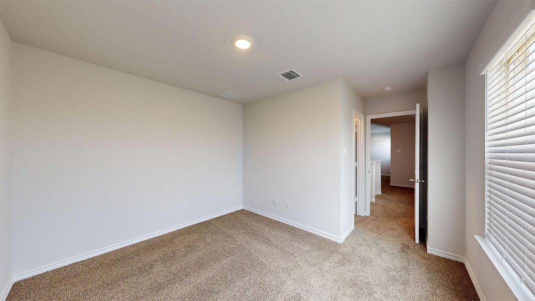 Unfurnished bedroom featuring light colored carpet and baseboards