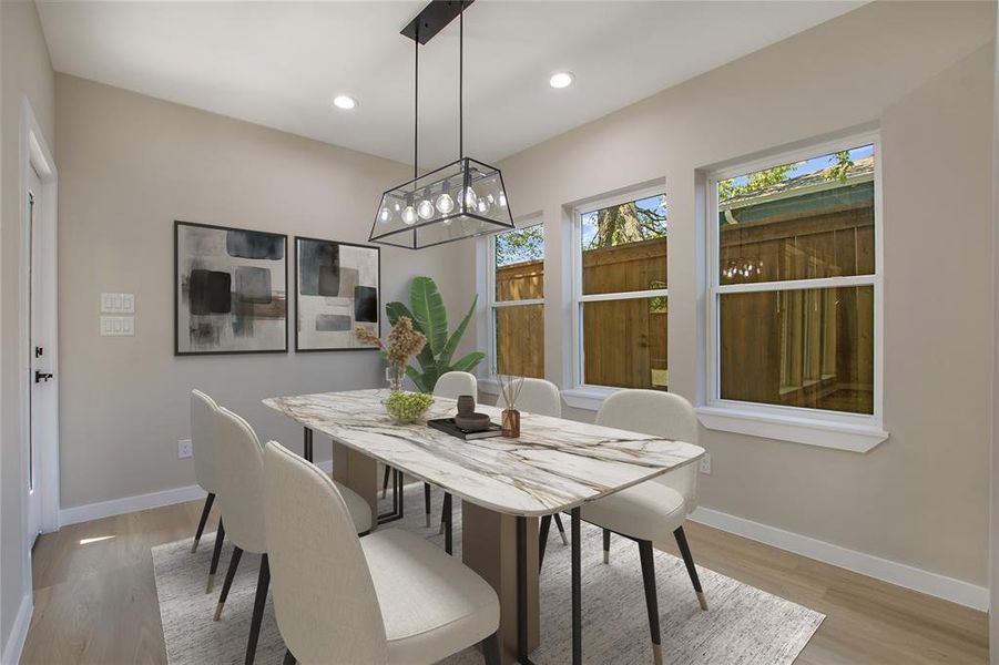 Dining space with light hardwood / wood-style flooring and a chandelier