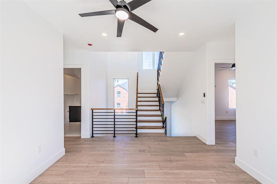 Staircase with a ceiling fan, recessed lighting, and wood finished floors