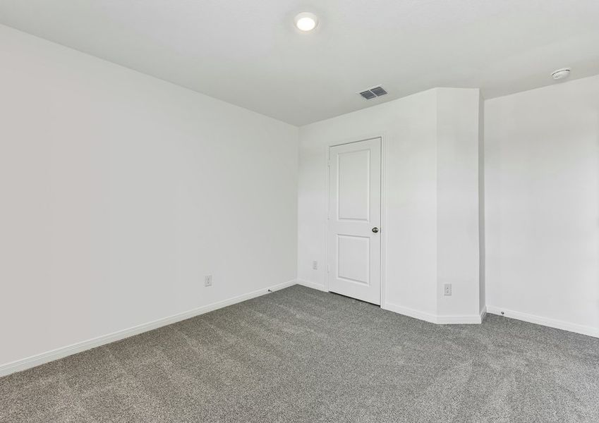 Carpeted secondary bedroom featuring neutral wall color and a closet doorway.