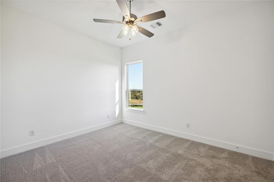 Carpeted spare room featuring ceiling fan