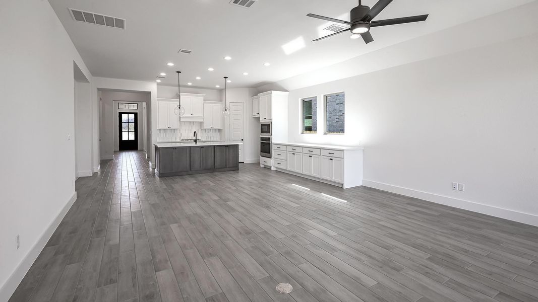 Kitchen featuring open floor plan, wood finished floors, a sink, and visible vents