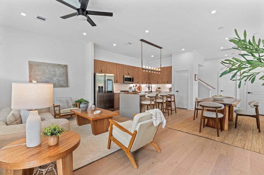 This stunning first-floor open-concept living space blends modern elegance with functional design. he living, dining, and kitchen areas flow seamlessly together, anchored by a statement kitchen island and illuminated by recessed lighting and bold pendant fixtures. Expansive windows and glass doors invite natural light, while contemporary finishes—such as matte black hardware, quartz countertops, and minimalist cabinetry—add a refined edge. Ideal for entertaining or relaxed everyday living!