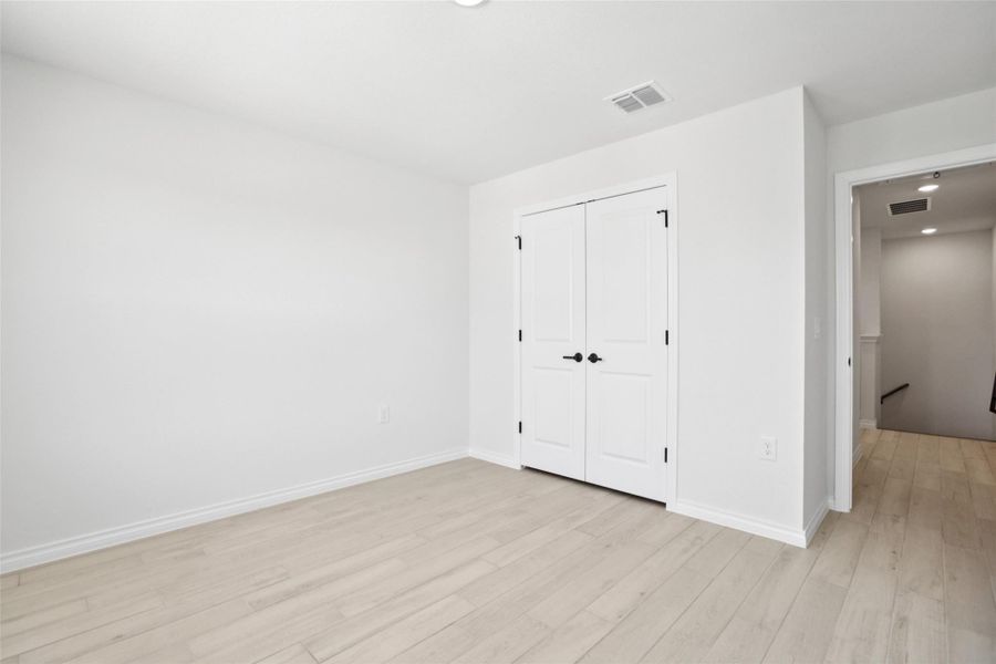 Unfurnished bedroom with light wood-type flooring, recessed lighting, and a closet