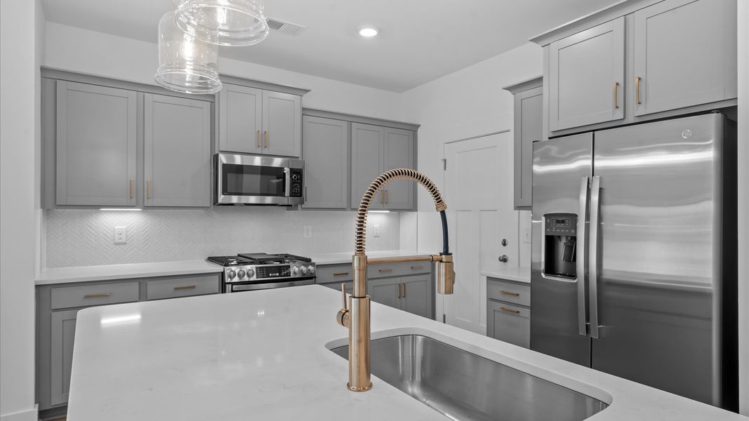 Memorable meals begin in this vibrant kitchen with pendant lighting and a thoughtfully designed island