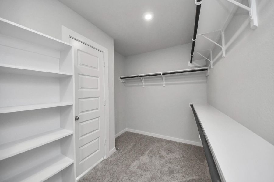 Walk-in closet that epitomizes luxury and practicality. This generously sized space features built-in shelving, offering abundant room for impeccable organization. High ceilings and recessed lighting create a bright and welcoming ambiance. Sample photo of completed home with similar floor plan. Actual colors and selections may vary. Walk-in closet that epitomizes luxury and practicality. This generously sized space features built-in shelving, offering abundant room for impeccable organization. High ceilings and recessed lighting create a bright and welcoming ambiance. Sample photo of completed home with similar floor plan. Actual colors and selections may vary.