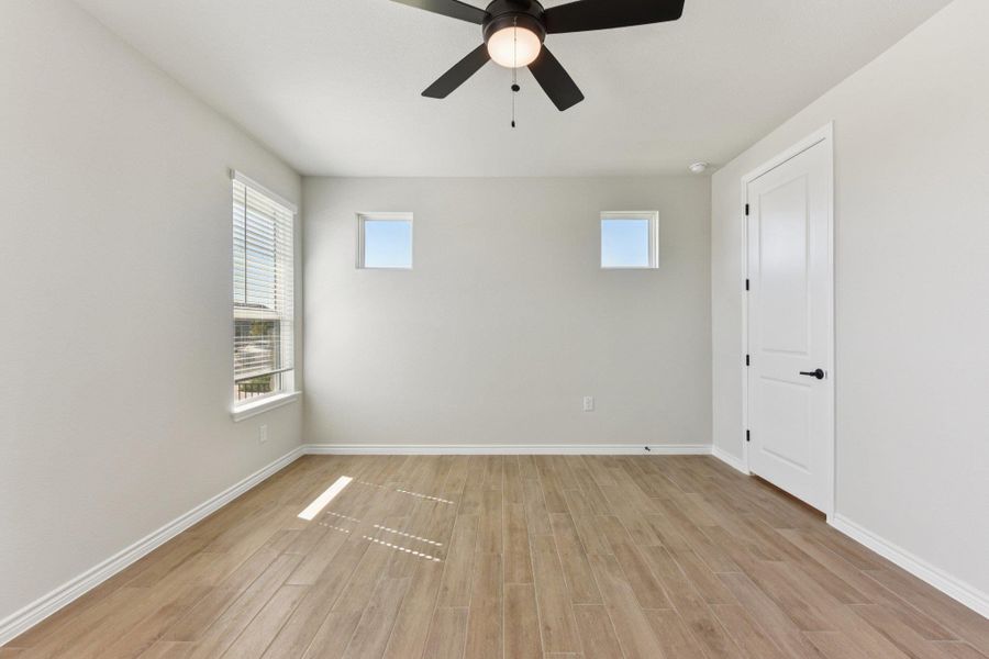 Spare room with plenty of natural light, light wood finished floors, and a ceiling fan