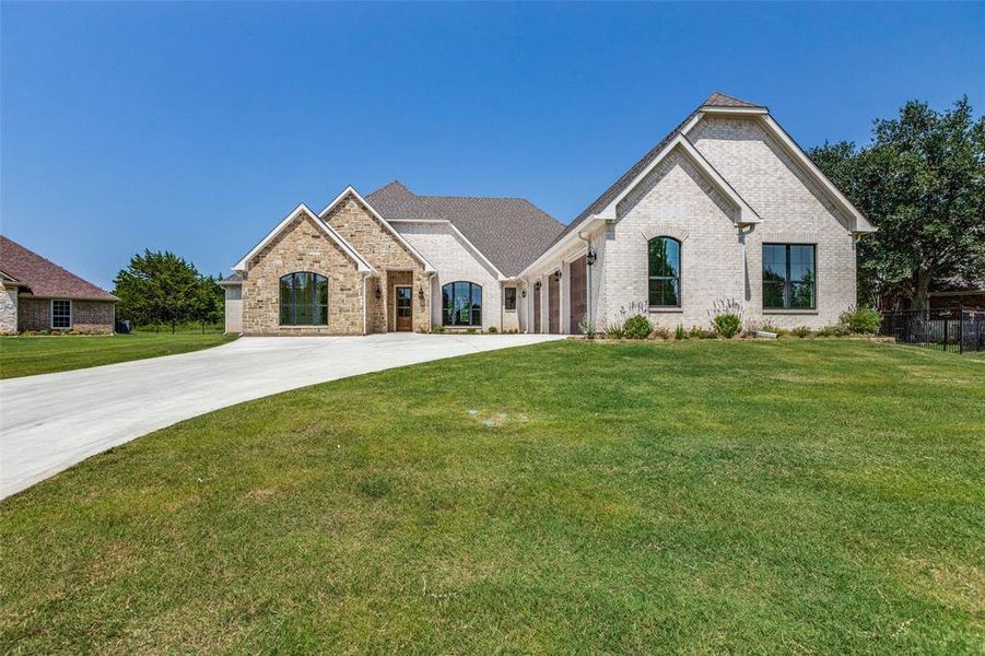 View of front of house with a garage and a front yard