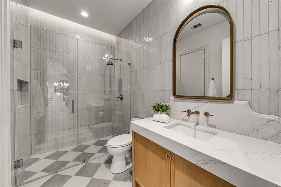 Bathroom featuring a shower stall, tile walls, vanity, and recessed lighting Bathroom featuring a shower stall, tile walls, vanity, and recessed lighting