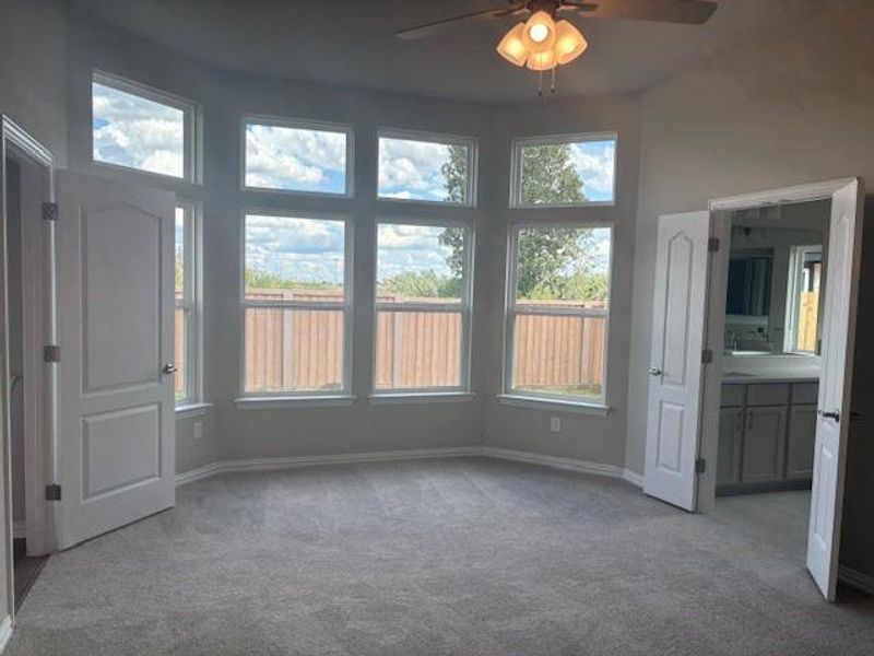 Unfurnished bedroom with ensuite bathroom, carpet floors, and ceiling fan Unfurnished bedroom with ensuite bathroom, carpet floors, and ceiling fan