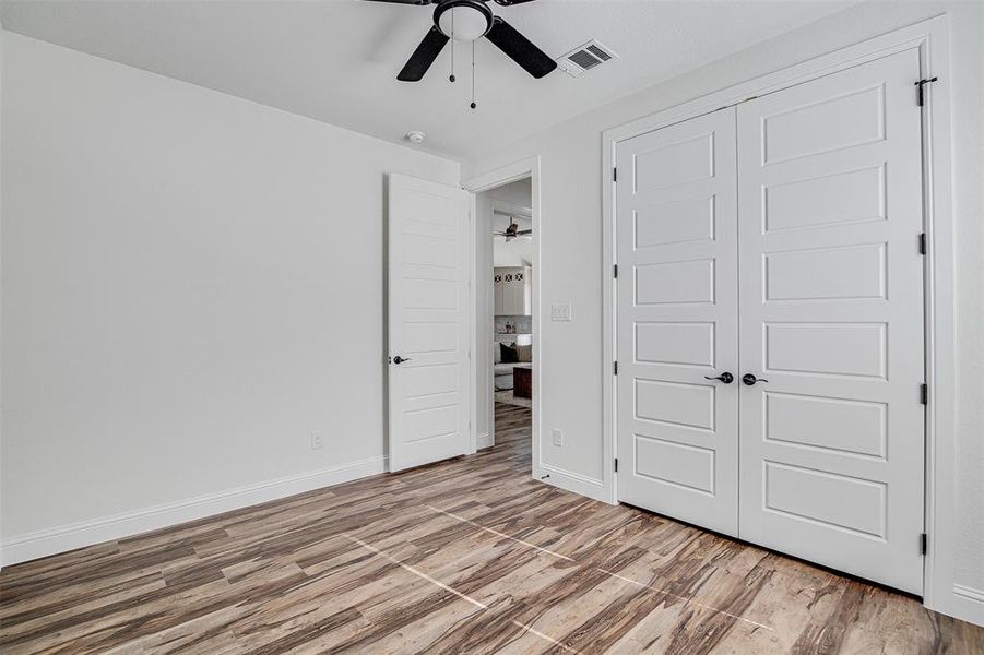 Unfurnished bedroom with ceiling fan, light hardwood / wood-style floors, and a closet