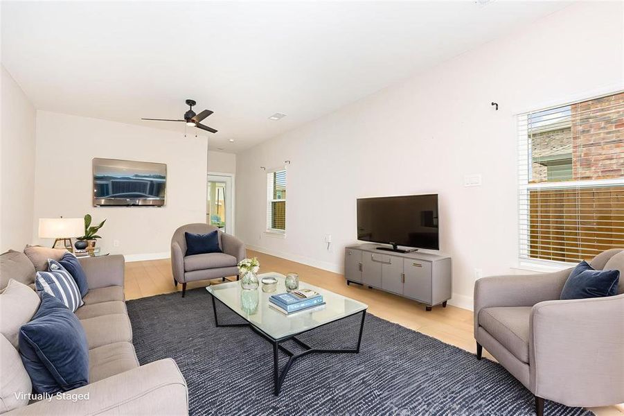 Living area with light wood-style flooring and a ceiling fan Living area with light wood-style flooring and a ceiling fan