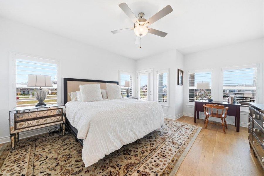 Natural light streams through multiple shuttered windows, illuminating the rich hardwood floors. Natural light streams through multiple shuttered windows, illuminating the rich hardwood floors.