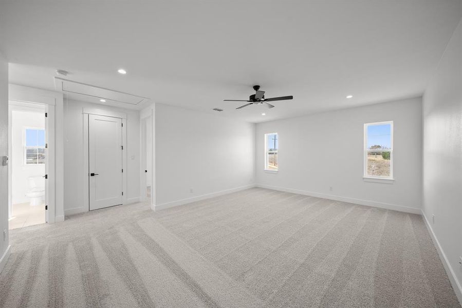 Empty room featuring attic access, recessed lighting, and light colored carpet