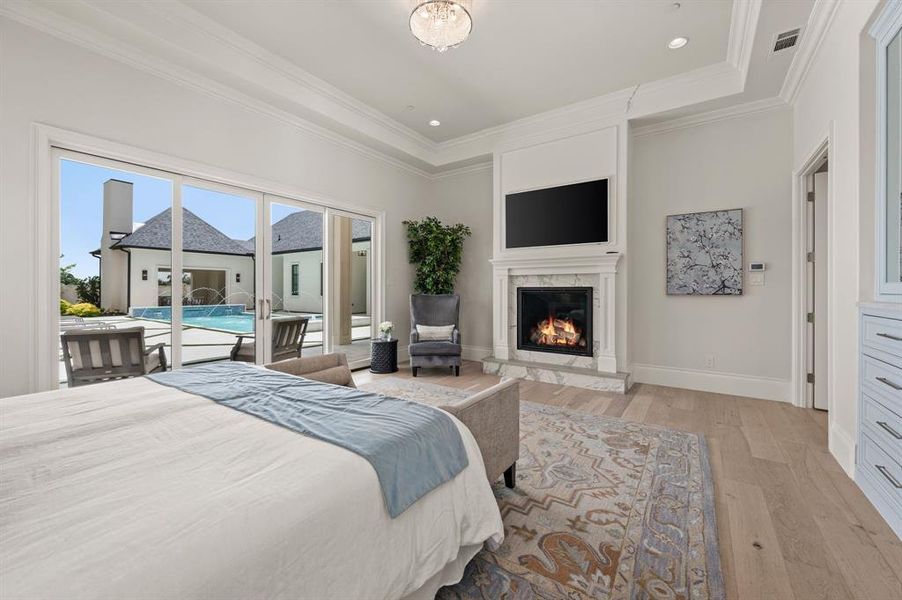Bedroom featuring access to exterior, a premium fireplace, light wood-style flooring, crown molding, and recessed lighting Bedroom featuring access to exterior, a premium fireplace, light wood-style flooring, crown molding, and recessed lighting