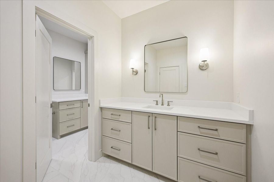 The Hollywood style bath is designed to make sharing easy, with separate vanity areas, ample storage and polished finishes that keep busy mornings organized without sacrificing style.