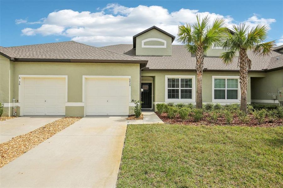Front exterior of a new home in Abbott Square: The Villas, Zephyrhills, FL, highlighting curb appeal (Image 23). Front exterior of a new home in Abbott Square: The Villas, Zephyrhills, FL, highlighting curb appeal (Image 23).