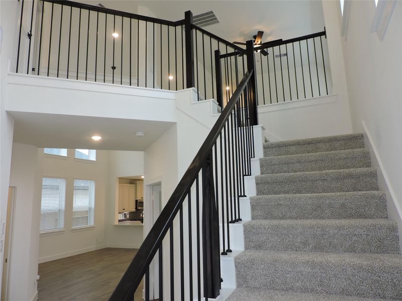 Going up the stairs with beautifully designed wrought iron spindles and stained wood rails