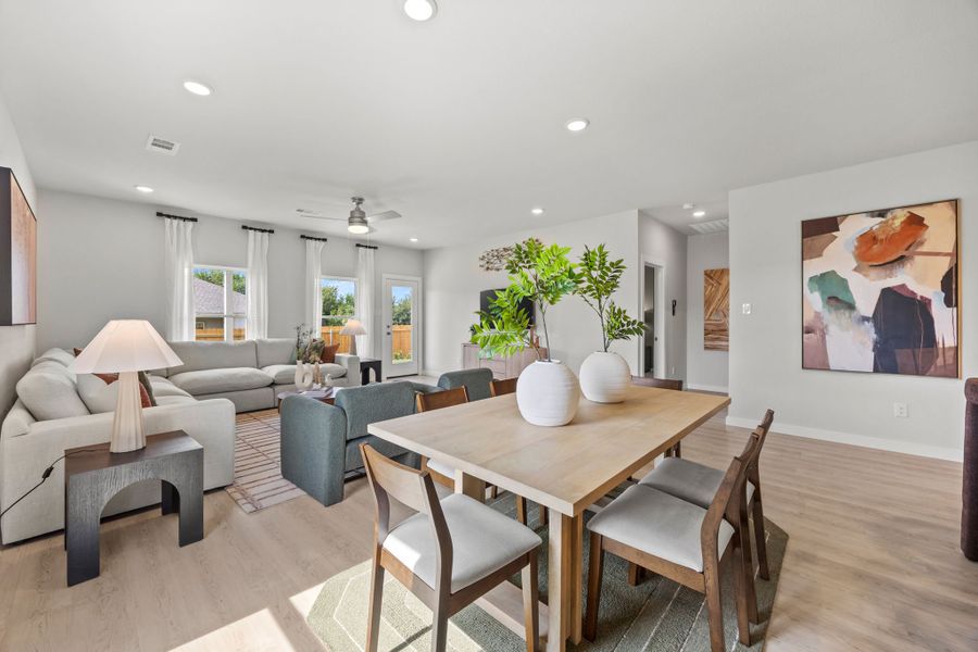 A living room with a table and chairs. A living room with a table and chairs.