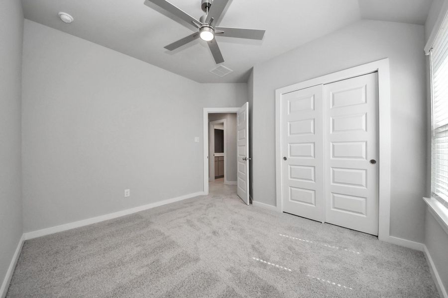 Generously sized secondary bedrooms featuring spacious closets, soft and inviting carpeting underfoot, large windows allowing plenty of natural light, and the added touch of privacy blinds for your personal retreat. Sample photo of completed home with similar floor plan. Actual colors and selections may vary.