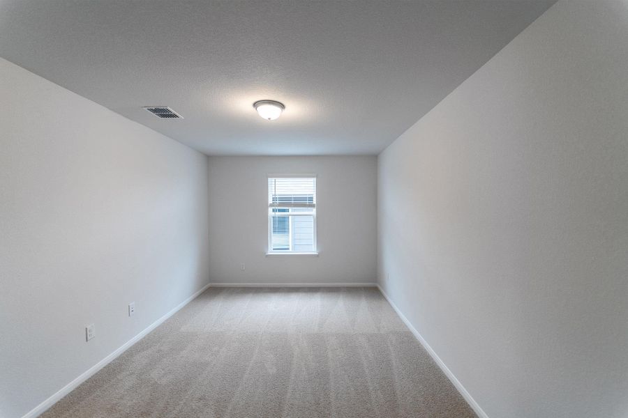 Spare room featuring light carpet and a textured ceiling