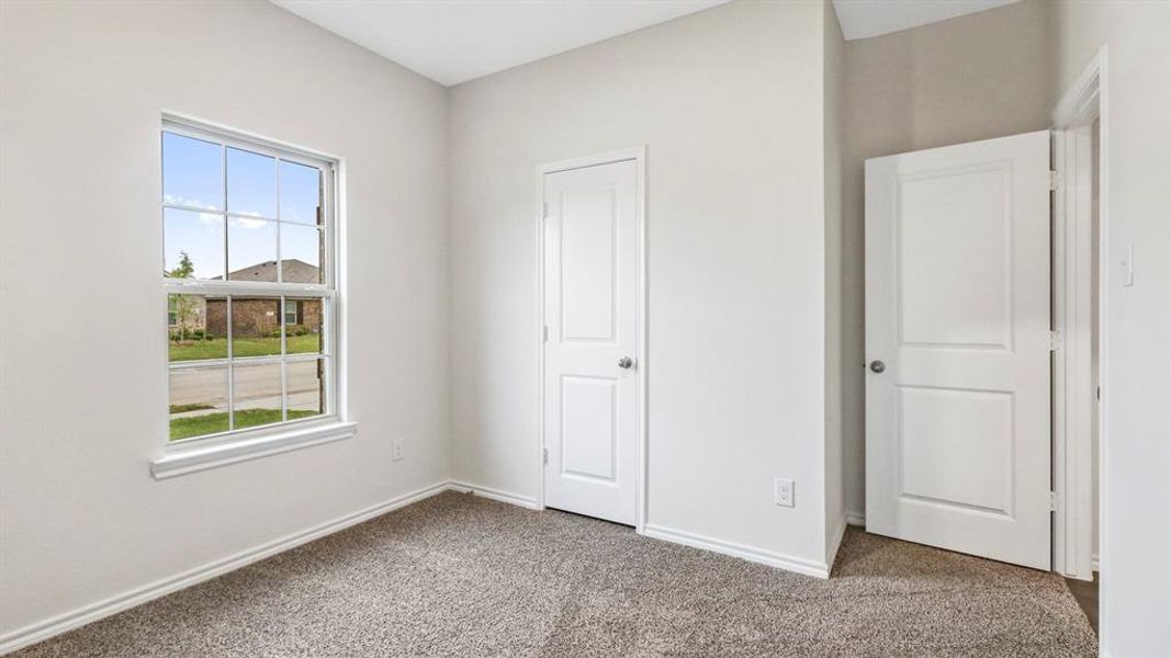 Carpeted room featuring a double-paned window with white trim, two white paneled doors, and light-colored walls