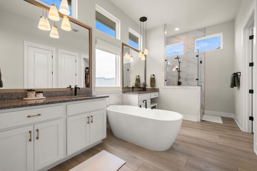 Luxurious primary bathroom with soaking tub and dual vanities.