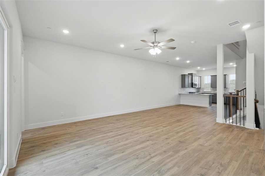 Unfurnished living room with ceiling fan, recessed lighting, and light wood-style floors