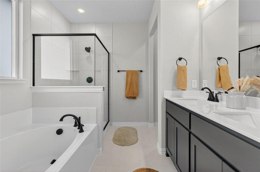 Bathroom with a garden tub, double vanity, a shower stall, and light tile patterned floors Bathroom with a garden tub, double vanity, a shower stall, and light tile patterned floors