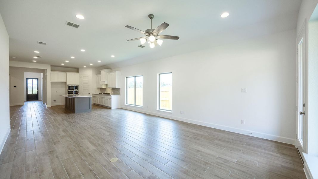Unfurnished living room with recessed lighting, healthy amount of natural light, light wood finished floors, and ceiling fan