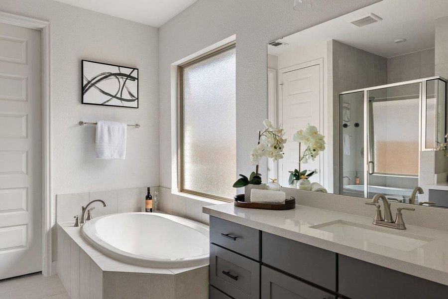 Luxurious primary bath with a deep soaking tub and a sleek double vanity.