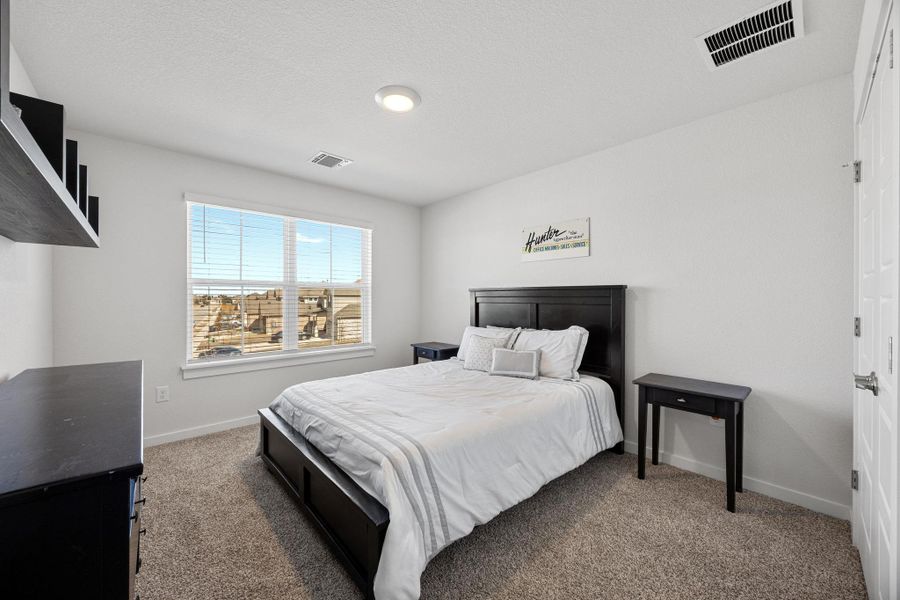 Carpeted bedroom with natural light.