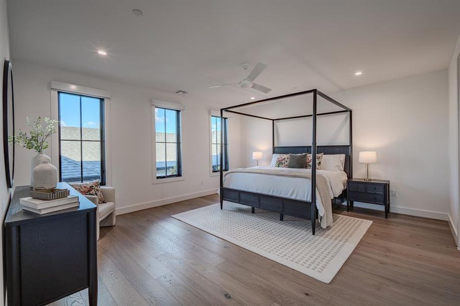 Bedroom with light wood finished floors, a ceiling fan, and recessed lighting Bedroom with light wood finished floors, a ceiling fan, and recessed lighting