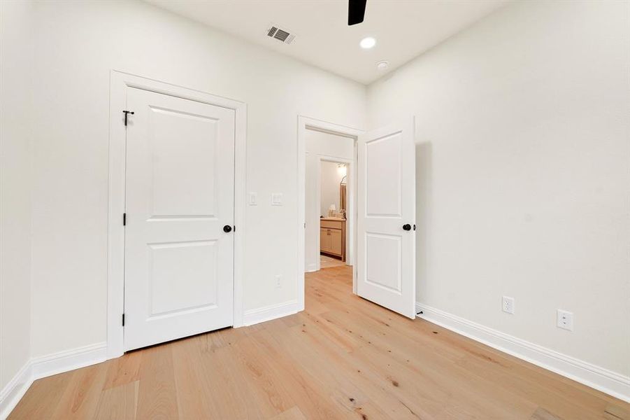 Light-filled interior space featuring wood-finish flooring, recessed lighting, white trim, and a ceiling fan