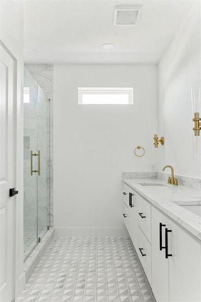 Bathroom featuring double vanity, walk in shower, and tile flooring