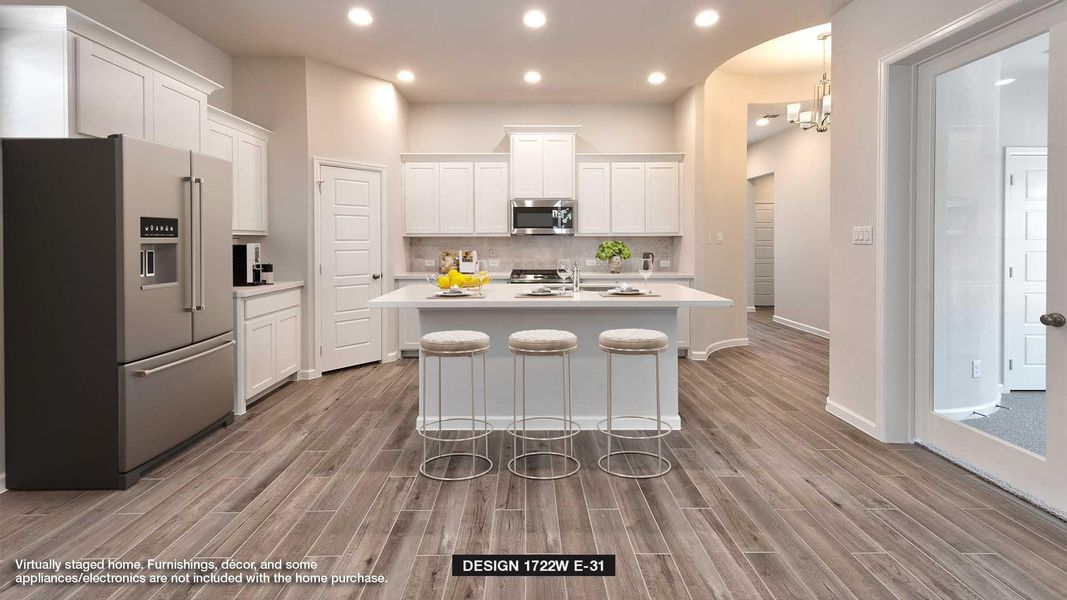 Kitchen featuring white cabinetry, a kitchen island with sink, appliances with stainless steel finishes, and a kitchen breakfast bar