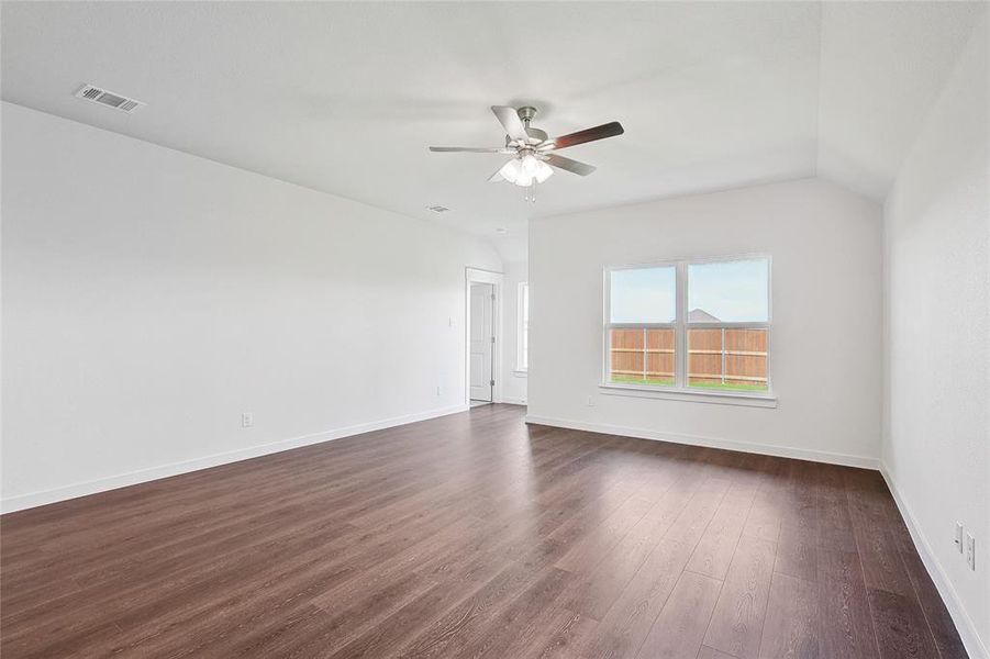 Spare room featuring ceiling fan, dark hardwood / wood-style floors, and vaulted ceiling