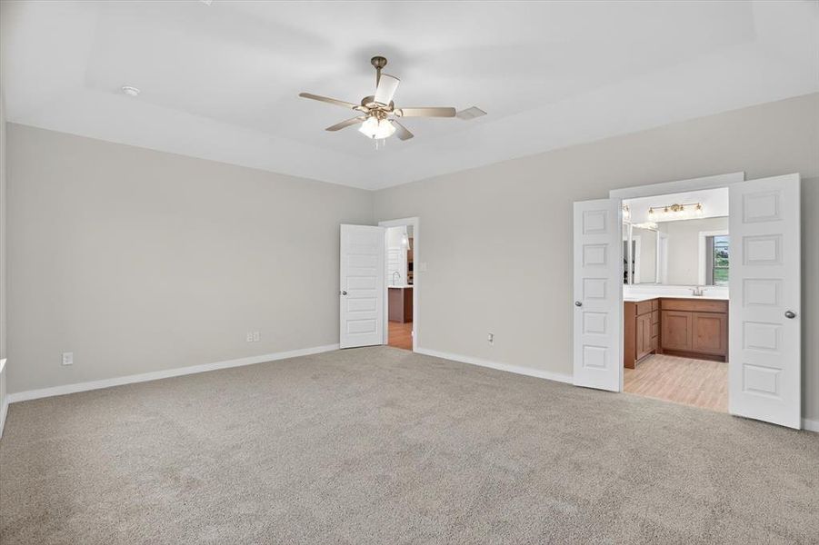 Spacious room featuring neutral carpet flooring and light wall paint