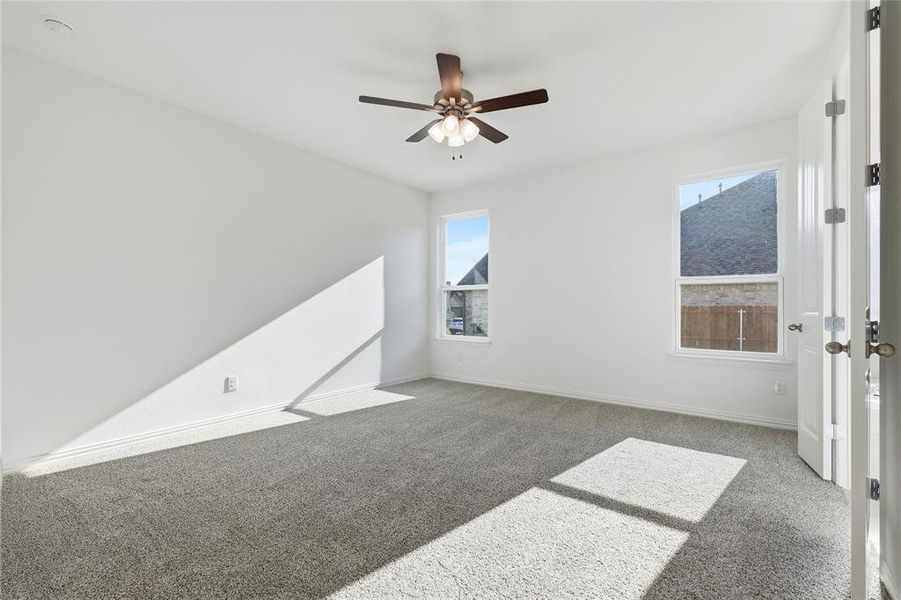 Empty room with carpet floors and a ceiling fan