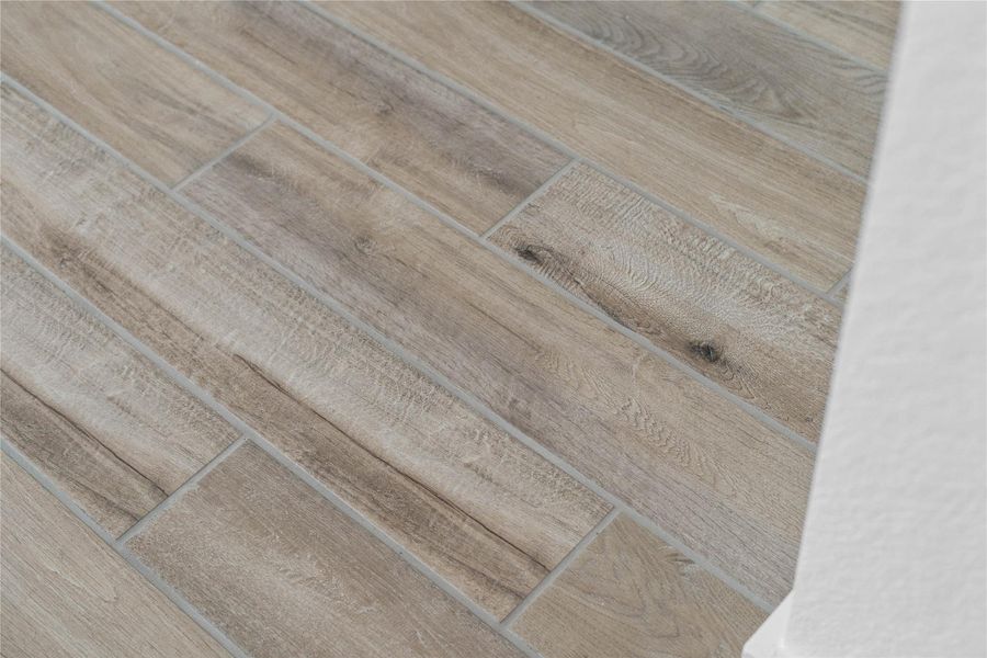 The photo highlights a durable and stylish wood-look tile flooring in Sahara Beige throughout the main living areas.