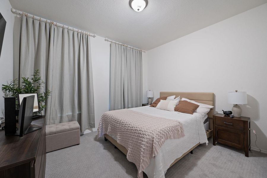 Bedroom featuring carpet and a textured ceiling