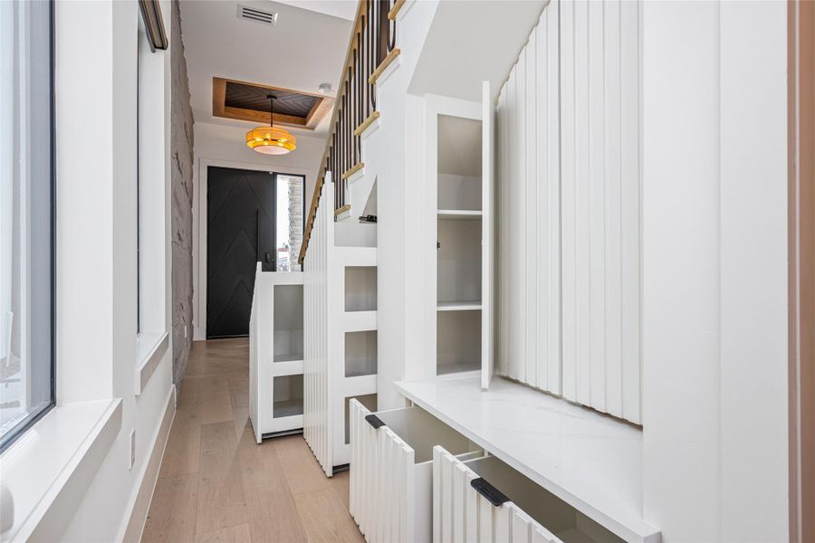 Smartly designed mud area beneath the staircase offers custom shoe shelving and a concealed coat closet—every inch is maximized.