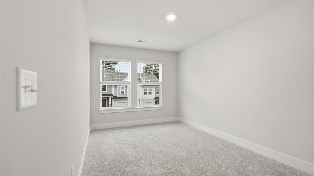 Inviting bedroom with tasteful finishes and large windows that create a fresh, open ambiance by DRB Homes Inviting bedroom with tasteful finishes and large windows that create a fresh, open ambiance by DRB Homes