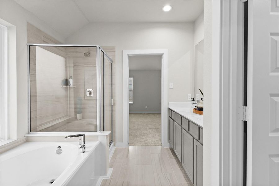 Primary bathroom features a soaking tub, separate glass-enclosed tiled shower, extended vanity, and bright neutral finishes. Primary bathroom features a soaking tub, separate glass-enclosed tiled shower, extended vanity, and bright neutral finishes.